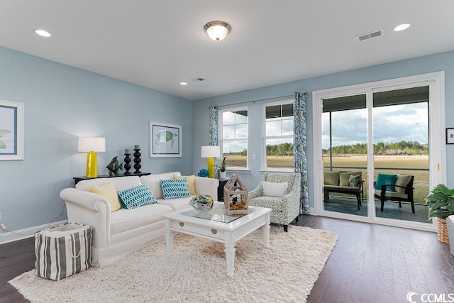 living area featuring recessed lighting, dark wood-style flooring, visible vents, and plenty of natural light