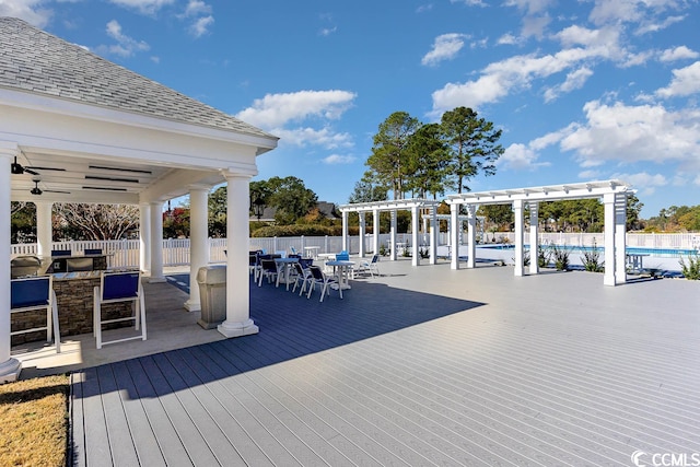 exterior space featuring a ceiling fan, fence, a community pool, a pergola, and a wooden deck