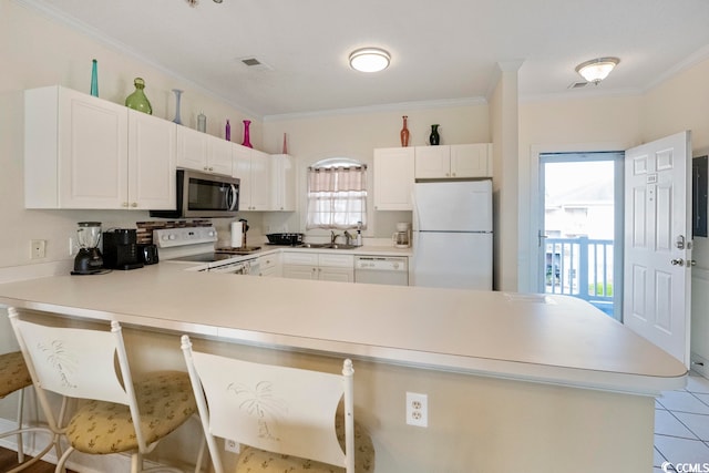 4856 Carnation Cir Unit 304, Myrtle Beach, SC 29577 - kitchen featuring white cabinets, a healthy amount of sunlight, light tile floors, and white appliances