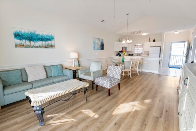 4856 Carnation Cir Unit 304, Myrtle Beach, SC 29577 - living room featuring a notable chandelier, light wood-type flooring, and vaulted ceiling