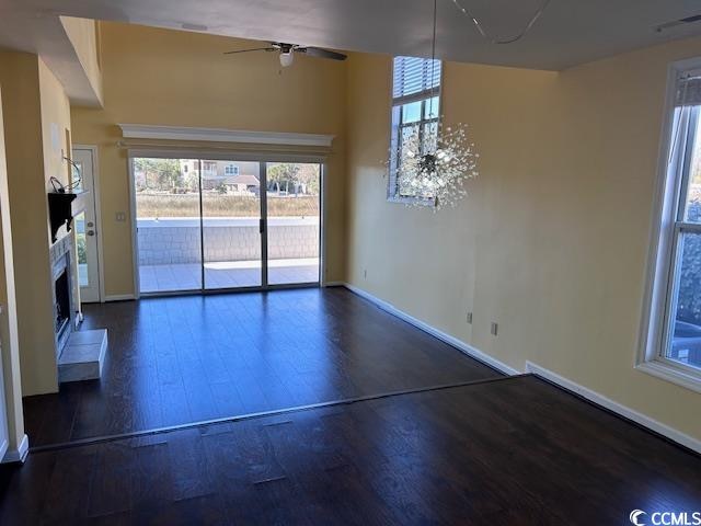 unfurnished living room with ceiling fan and dark hardwood / wood-style floors