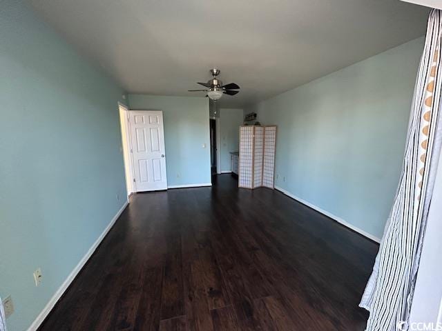 unfurnished room featuring ceiling fan and dark wood-type flooring