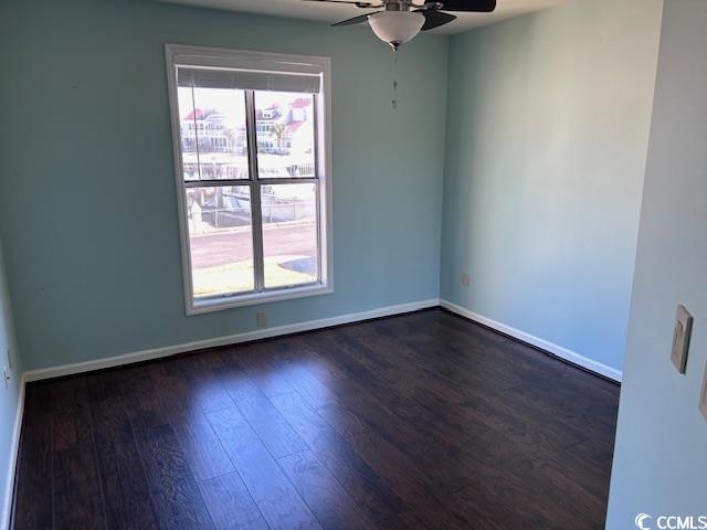 unfurnished room with ceiling fan and dark wood-type flooring