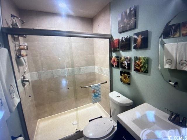 bathroom featuring vanity, toilet, and walk in shower