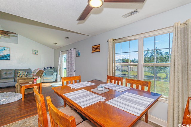 dining space with hardwood / wood-style floors, ceiling fan, and lofted ceiling