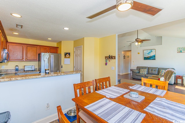 dining room with lofted ceiling, a textured ceiling, ceiling fan, and hardwood / wood-style flooring