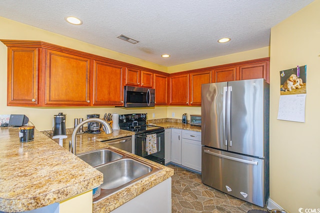 kitchen featuring appliances with stainless steel finishes, sink, a textured ceiling, dark tile flooring, and gray cabinets