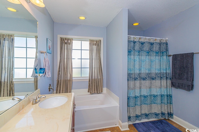 bathroom featuring a washtub, a textured ceiling, and oversized vanity