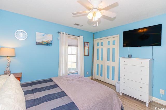 bedroom with a closet, ceiling fan, and light wood-type flooring