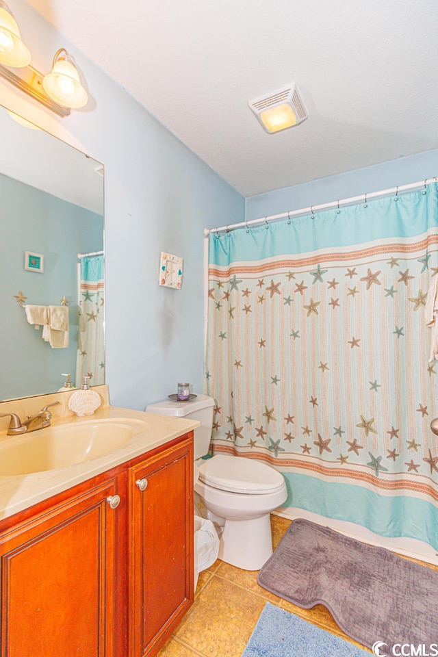 bathroom with tile flooring, oversized vanity, and toilet