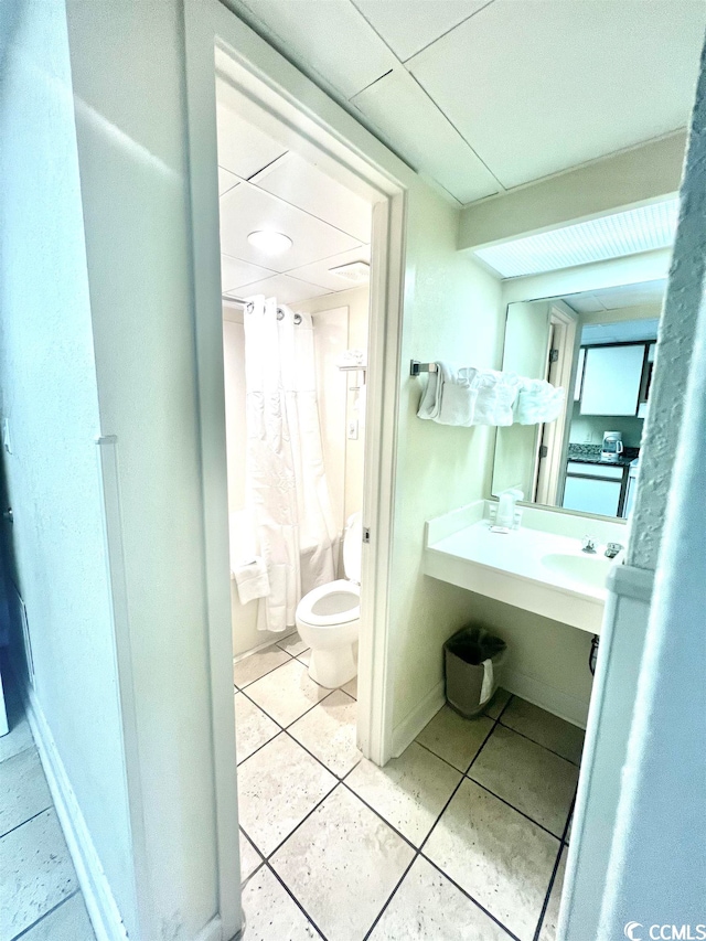 bathroom with toilet, large vanity, and tile flooring