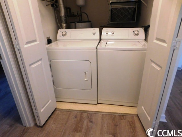 laundry room featuring washer and clothes dryer, electric dryer hookup, and hardwood / wood-style flooring