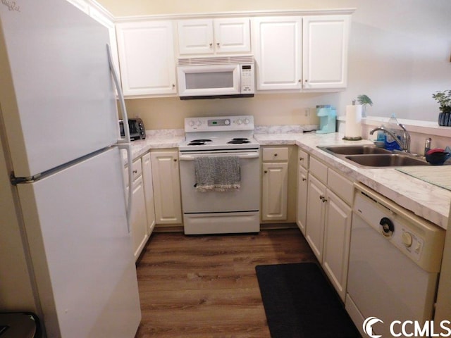 kitchen featuring white cabinets, white appliances, dark hardwood / wood-style floors, and sink