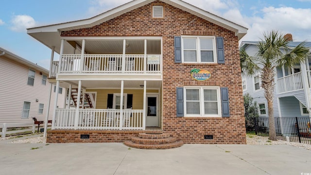 view of front of property featuring covered porch, brick siding, fence, and crawl space