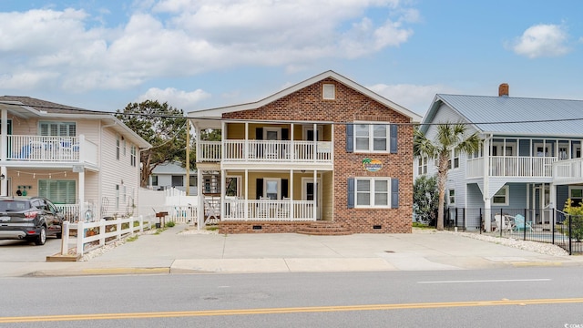 view of front of property with driveway, crawl space, fence, a porch, and brick siding