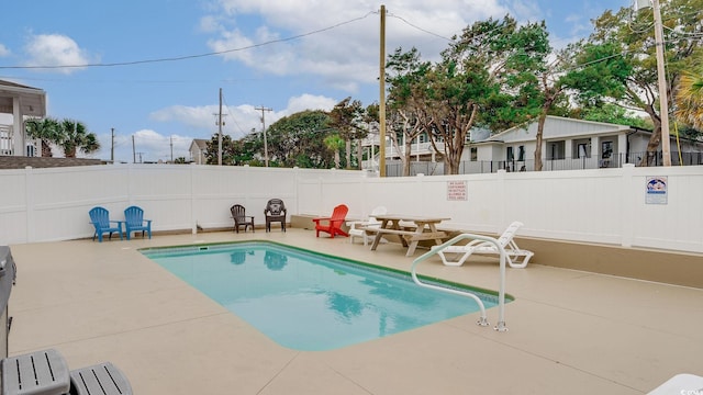 community pool with a fenced backyard and a patio