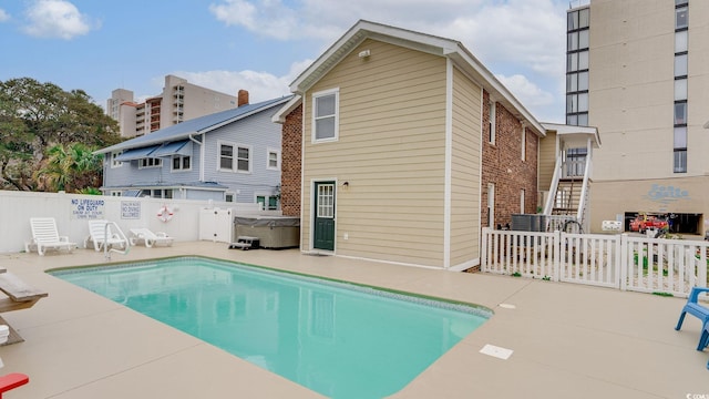 view of pool with a patio, a fenced backyard, stairway, a fenced in pool, and a hot tub