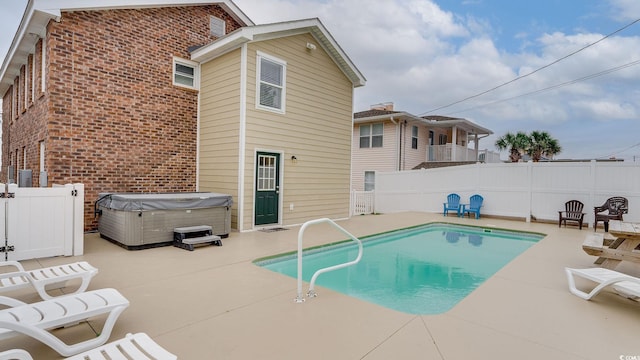 view of swimming pool featuring a patio, a fenced backyard, a fenced in pool, and a hot tub