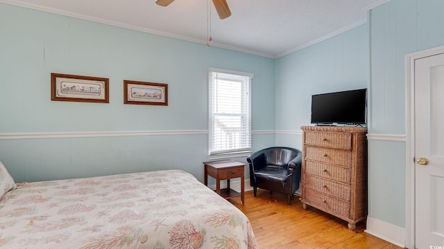 bedroom featuring ceiling fan, crown molding, and wood finished floors