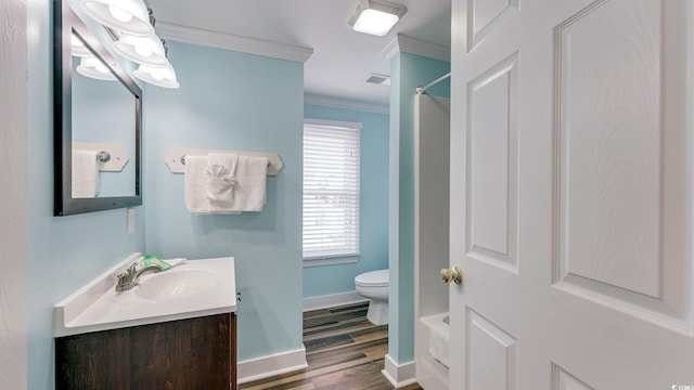 bathroom with toilet, wood finished floors, vanity, visible vents, and ornamental molding