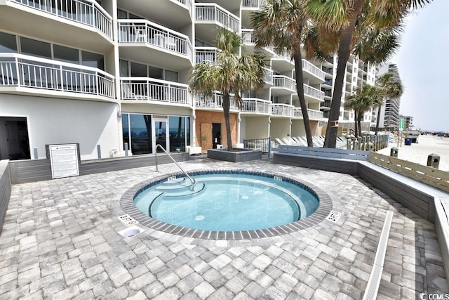 view of swimming pool featuring a community hot tub and a patio area