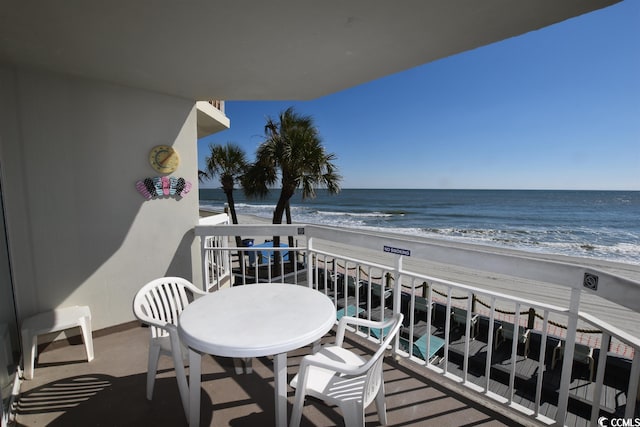 balcony featuring a view of the beach and a water view