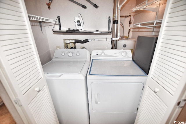 laundry room featuring water heater and washer and dryer