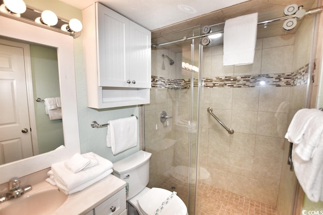 bathroom with vanity, a shower with shower door, and toilet