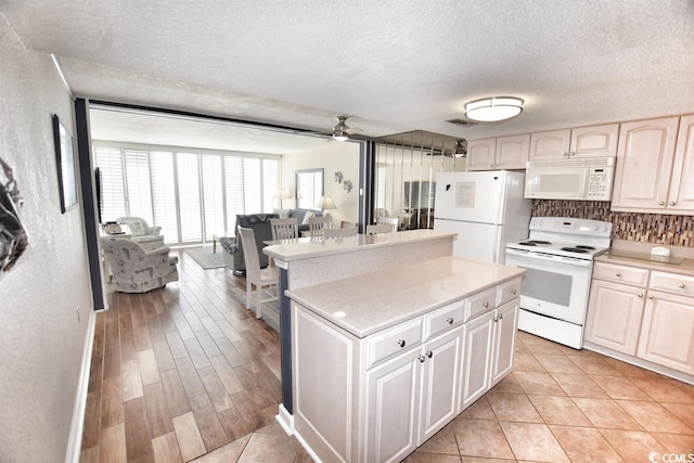 kitchen featuring light hardwood / wood-style flooring, white appliances, light brown cabinets, a textured ceiling, and ceiling fan