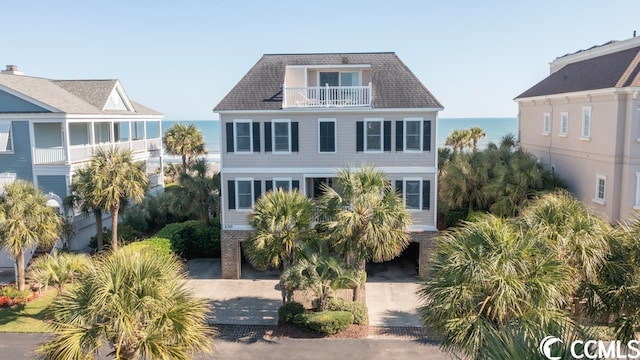 raised beach house with a balcony and a water view