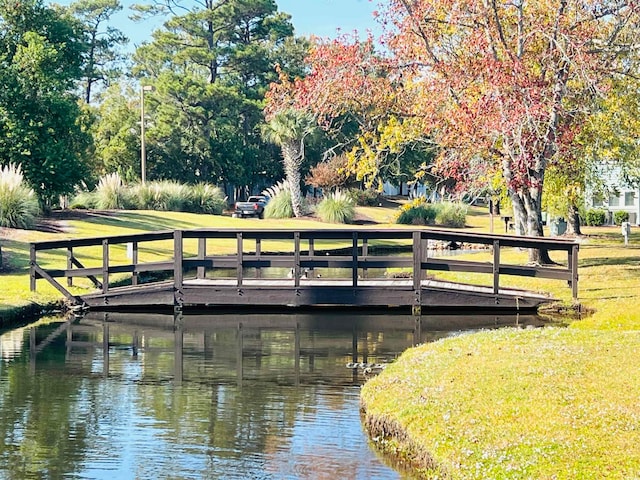 dock area featuring a water view and a lawn