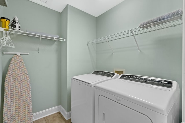 laundry room with independent washer and dryer and light tile patterned floors