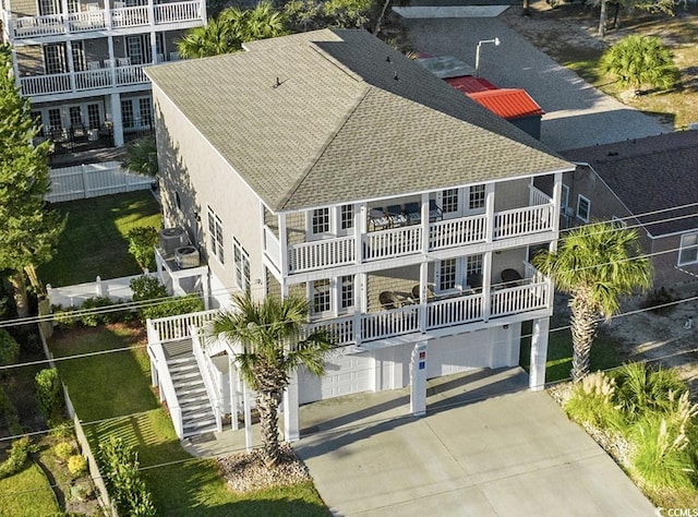 1010 Perrin Dr, North Myrtle Beach, SC 29582 - back of house with a shingled roof, driveway, an attached garage, stairway, and central AC