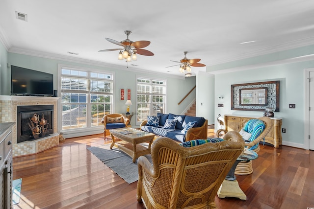 living room featuring ornamental molding, hardwood / wood-style floors, a fireplace, and ceiling fan