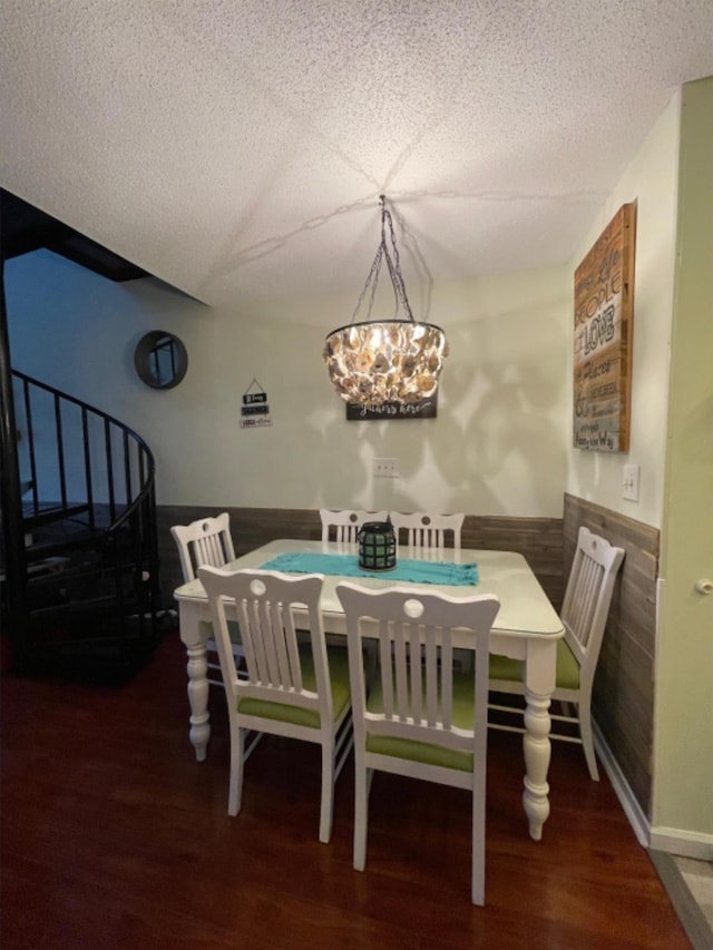 dining area featuring dark hardwood / wood-style floors, an inviting chandelier, and wooden walls