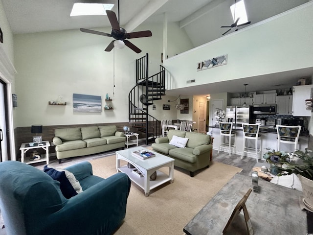 living room with beam ceiling, a skylight, high vaulted ceiling, and ceiling fan