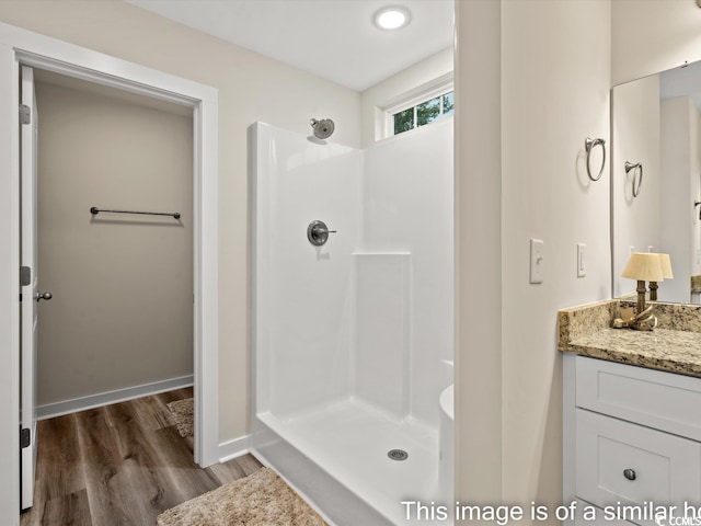 bathroom with a shower, vanity, and hardwood / wood-style floors