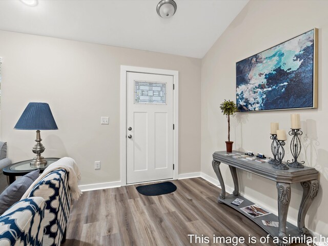 entryway with lofted ceiling and hardwood / wood-style flooring