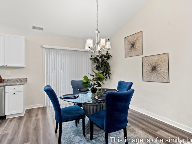 dining room with light hardwood / wood-style floors, lofted ceiling, and a chandelier