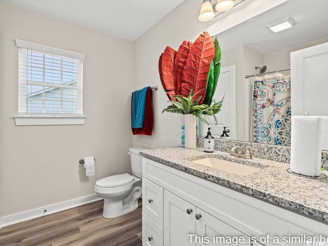 bathroom with curtained shower, hardwood / wood-style flooring, vanity, and toilet