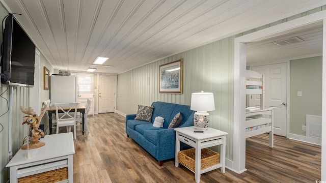 living area featuring wooden ceiling, baseboards, visible vents, and wood finished floors