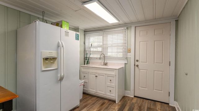 kitchen featuring white refrigerator with ice dispenser, dark wood-type flooring, a sink, white cabinetry, and light countertops