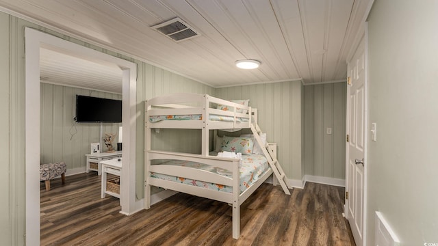 bedroom with visible vents, baseboards, and wood finished floors