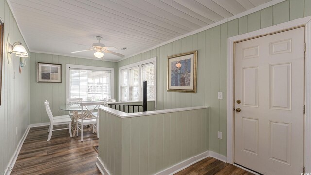 interior space featuring dark wood-type flooring, ornamental molding, and baseboards