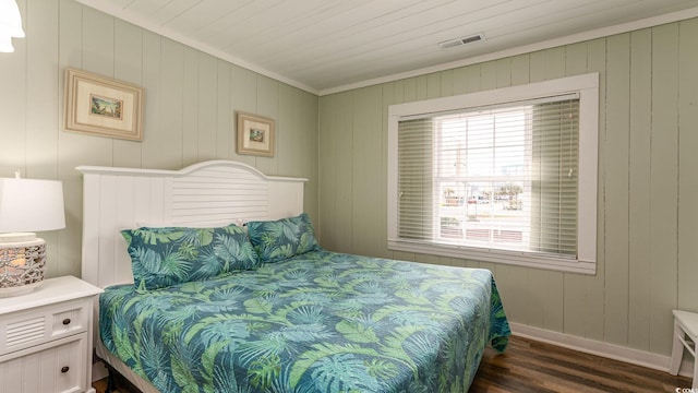 bedroom featuring visible vents, baseboards, and wood finished floors