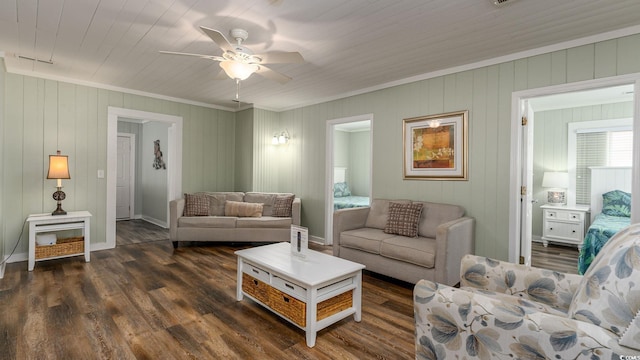 living area featuring ornamental molding, dark wood finished floors, a ceiling fan, and baseboards