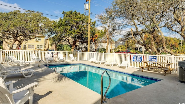 pool with a patio and fence