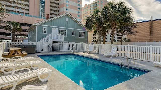 view of swimming pool with a fenced in pool, a patio area, fence, and a hot tub