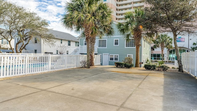 exterior space featuring a fenced in pool, uncovered parking, and fence