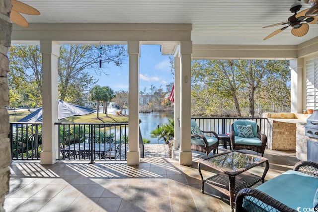 sunroom / solarium with plenty of natural light, a water view, and ceiling fan